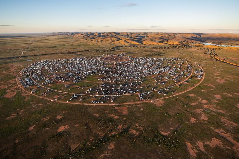 Aerial view of Mundi Mundi Bash festival campsite arranged in concentric circles across the Australian Outback plains near Broken Hill.